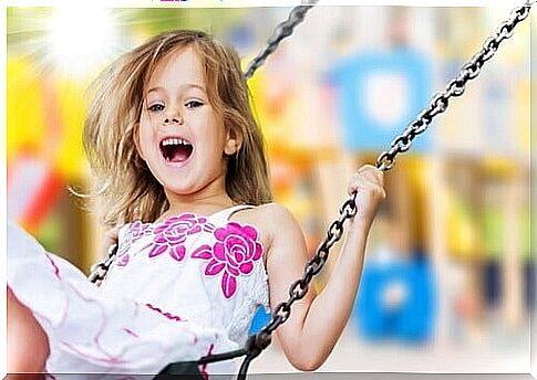 Happy little girl swinging on a swing