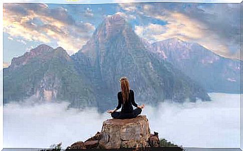 Woman meditating in the mountains.