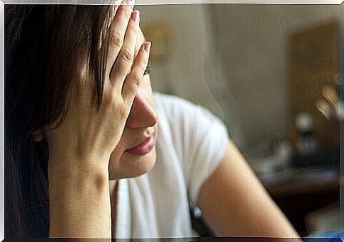 Tired woman with hand on forehead