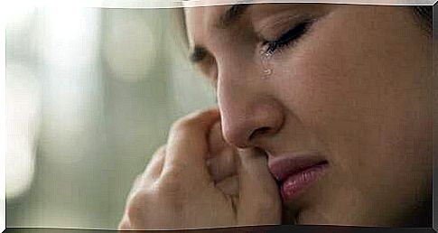 Woman crying wiping her tears.