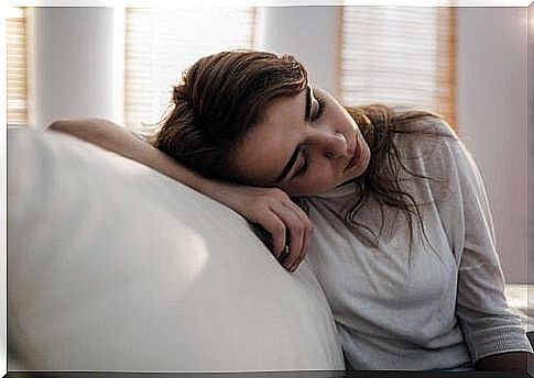 Depressed woman leaning on sofa