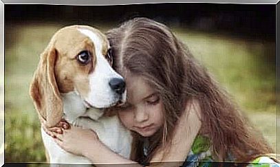 Little girl hugs her dog.