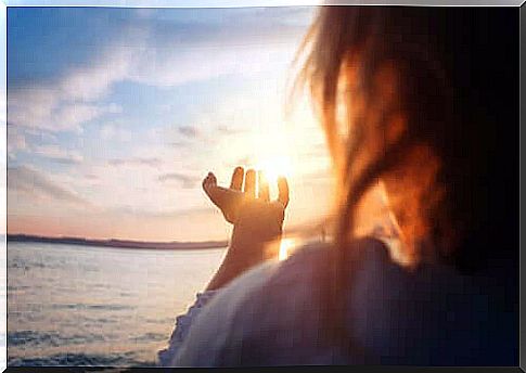 Woman with hands pointing to the sun