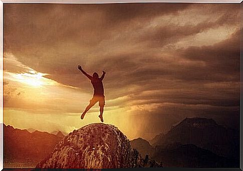 Boy jumping on top of a mountain