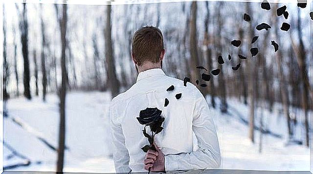 Man hides a black rose behind his back