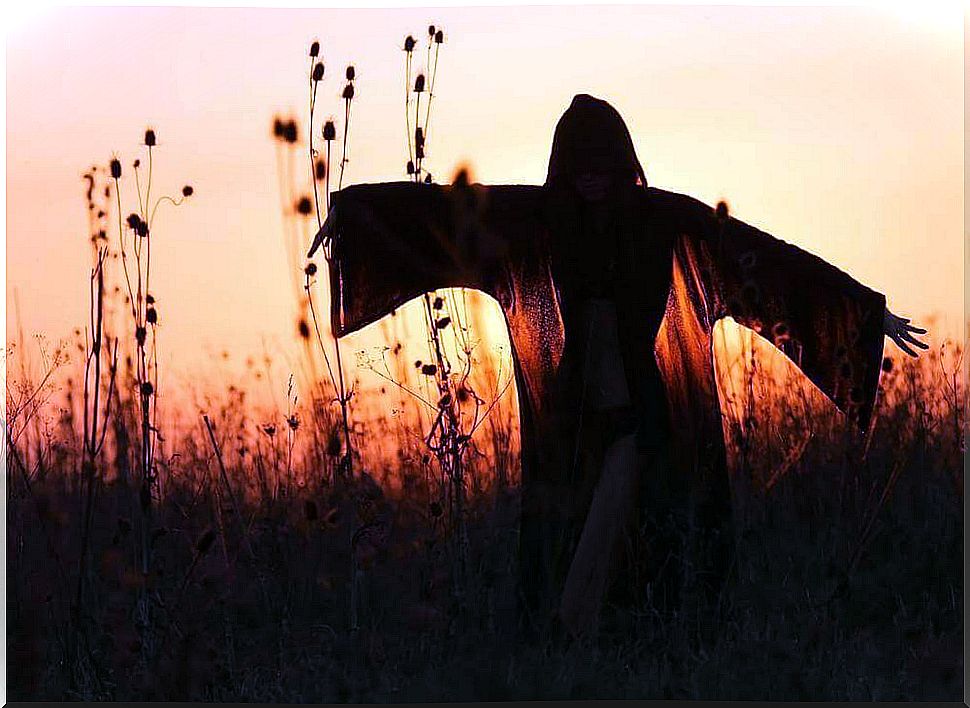 Woman with cape at sunset