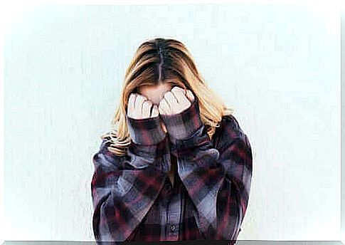 Shy woman covering her face with her hands.